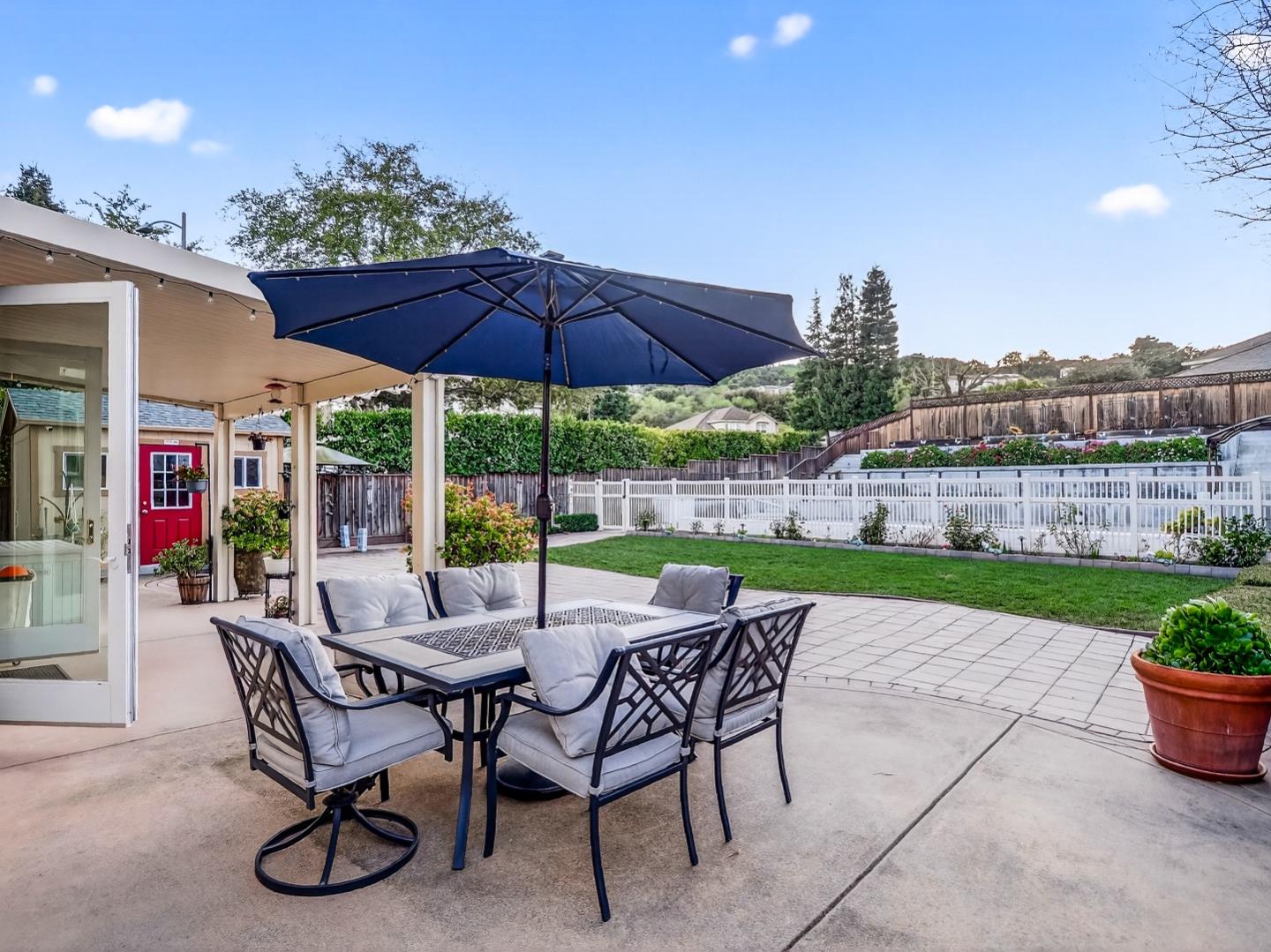9123 Rancho Hills Drive Gilroy, CA 95020 - Photo 14 of 26 a view of a patio with a table and chairs under an umbrella