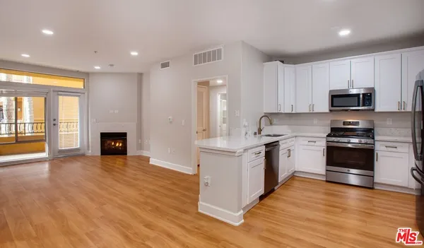 a kitchen with granite countertop a stove top oven and cabinets
