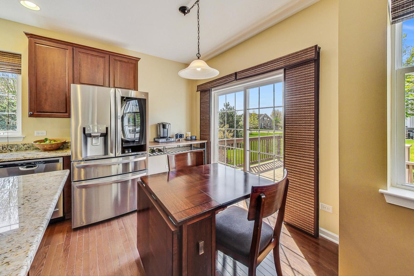 1224 Falcon Ridge Drive Elgin, IL 60124 - Photo 11 of 27 a kitchen with stainless steel appliances granite countertop a refrigerator a stove a sink dishwasher with a dining table and chairs