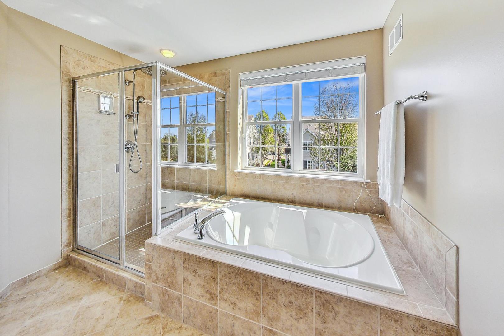 1224 Falcon Ridge Drive Elgin, IL 60124 - Photo 15 of 27 a white bath tub sitting in a bathroom next to a window