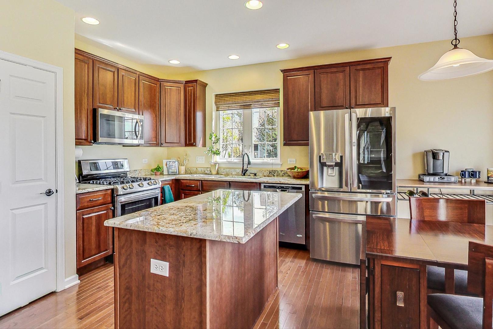 1224 Falcon Ridge Drive Elgin, IL 60124 - Photo 8 of 27 a kitchen with stainless steel appliances granite countertop a refrigerator a stove top oven a sink dishwasher and wooden cabinets with wooden floor