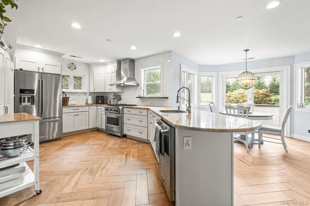 a kitchen with stainless steel appliances granite countertop a sink refrigerator and cabinets