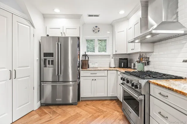 a kitchen with stainless steel appliances granite countertop a refrigerator sink and stove
