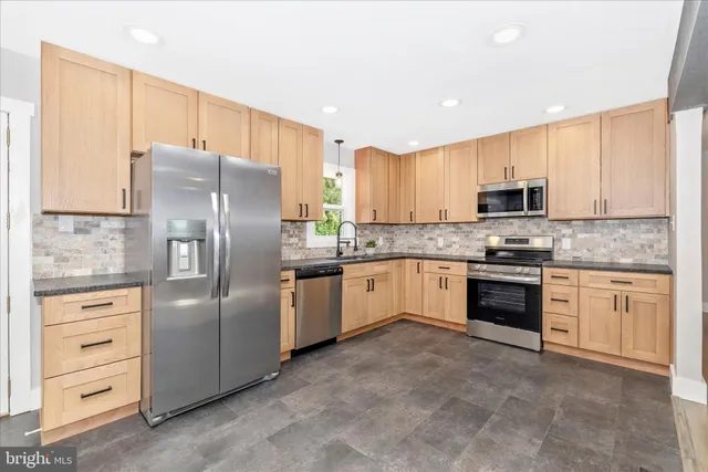 a spacious bedroom with a bed a dresser and a large mirror
