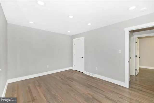 an empty room with wooden floor and a window