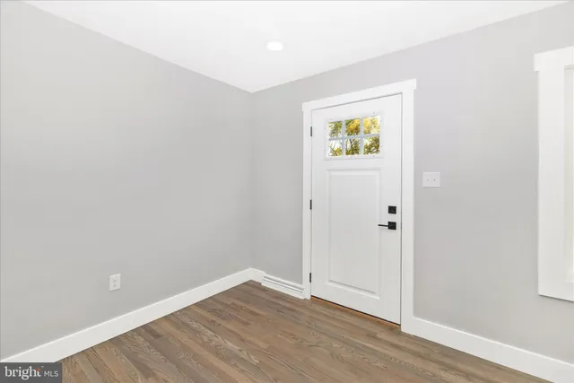 an empty room with windows and mirror