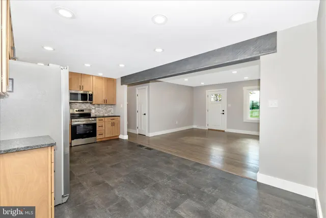 a kitchen with granite countertop stainless steel appliances a refrigerator a stove top oven a sink and dishwasher