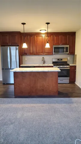 a kitchen with stainless steel appliances granite countertop a stove a sink and a microwave