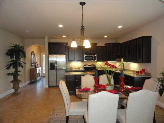 457 Pin Oak Loop Santa Rosa Beach, FL 32459 - Photo 1 of 14 a kitchen with stainless steel appliances kitchen island granite countertop a dining table chairs and a refrigerator