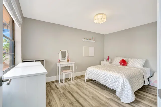 a bathroom with a toilet a sink a mirror and a window