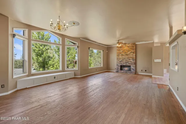 a view of a livingroom with a ceiling fan and hardwood floor