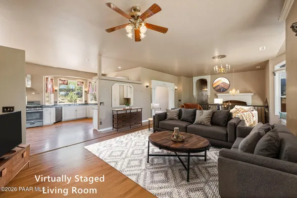 a view of a livingroom with wooden floor and a ceiling fan