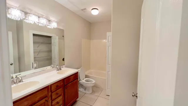 a bathroom with a granite countertop sink a toilet and shower