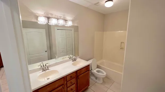 a bathroom with a double vanity sink toilet and a mirror