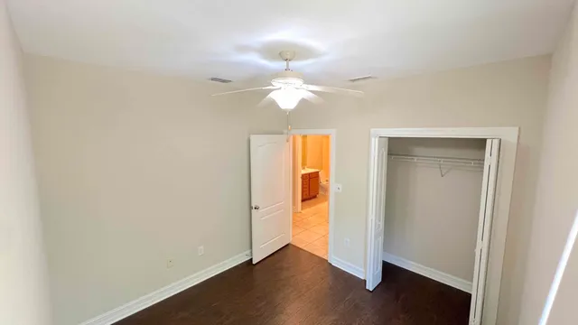an empty room with a window and a ceiling fan