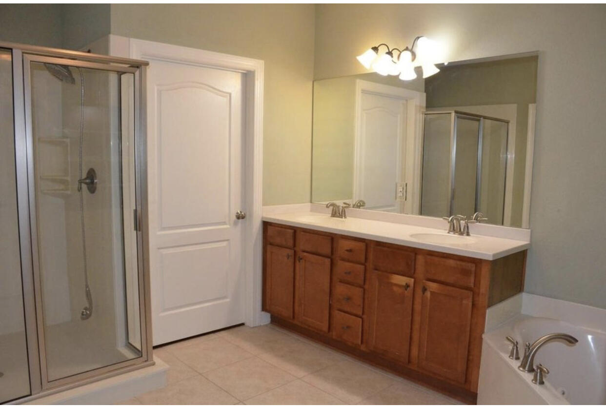 4230 Jade Loop Destin, FL 32541 - Photo 34 of 37 a bathroom with a double vanity sink a mirror and a shower