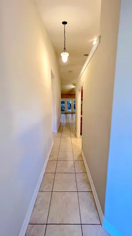 a view of a hallway with wooden floor and a door
