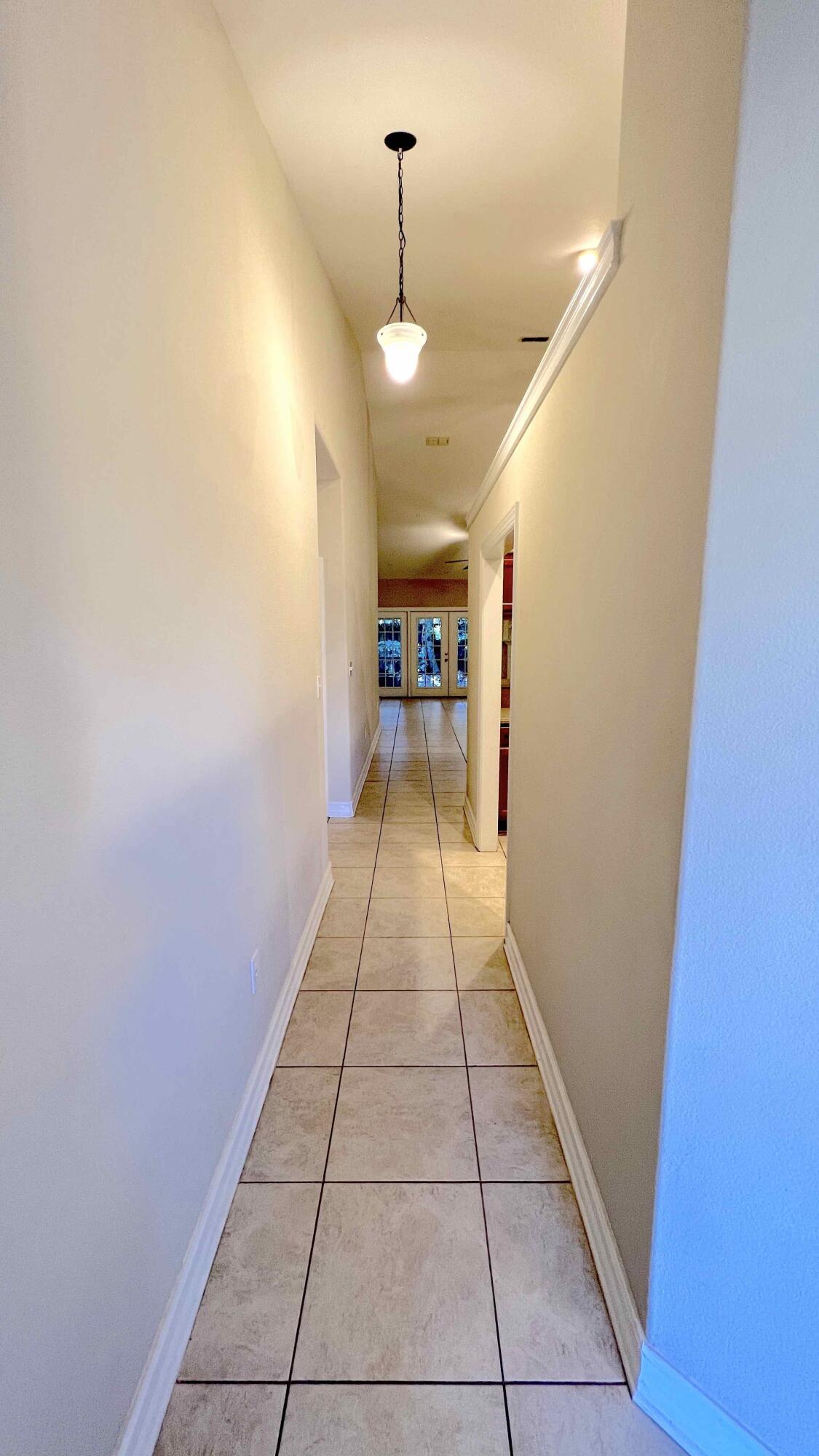 4230 Jade Loop Destin, FL 32541 - Photo 7 of 37 a view of a hallway with wooden floor and a door
