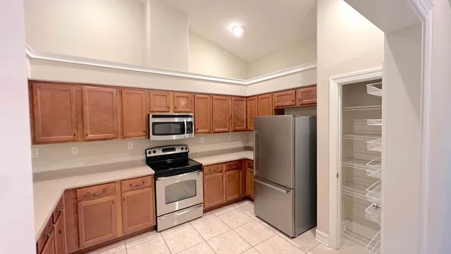 a kitchen with stainless steel appliances granite countertop a refrigerator and a stove top oven