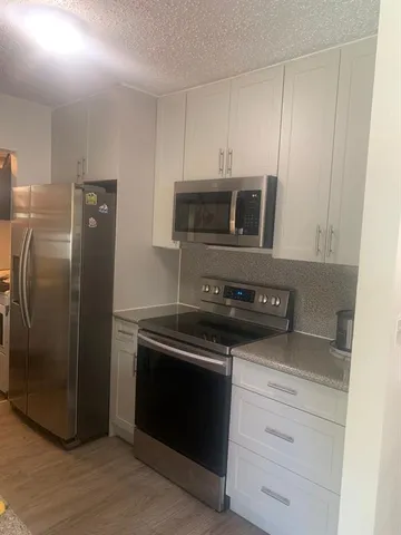 a kitchen with a refrigerator stove and microwave