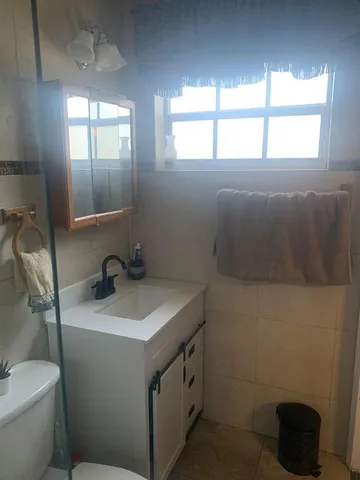 a bathroom with a sink toilet and window