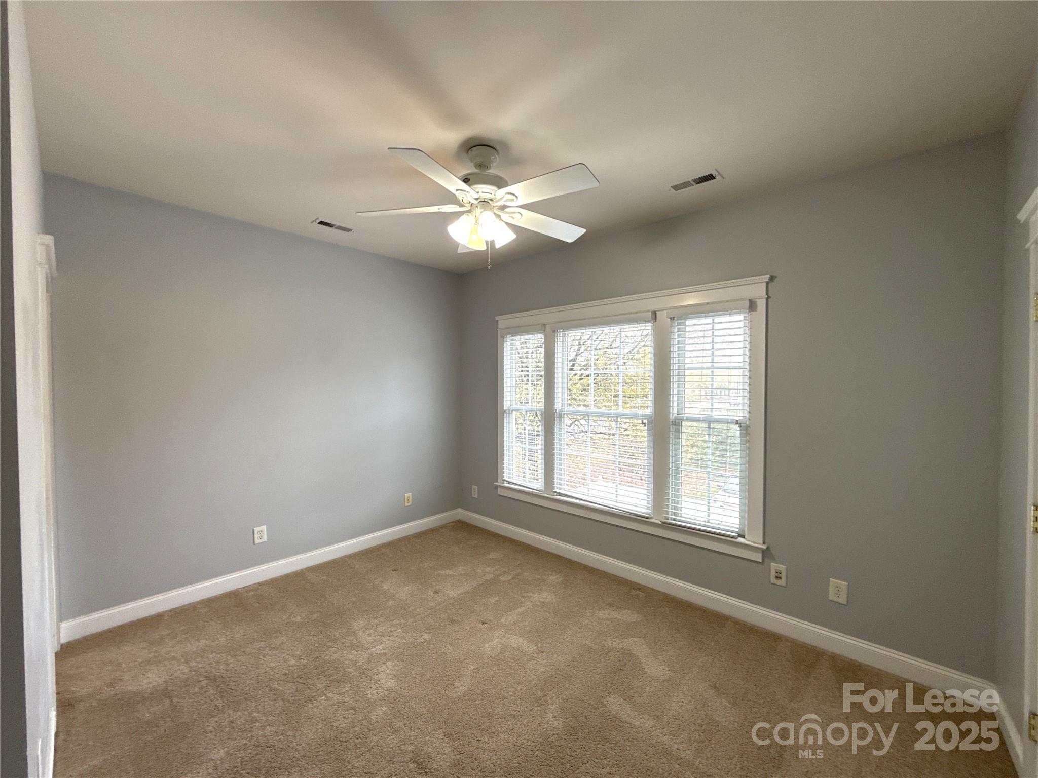 3003 Colonel Springs Way Fort Mill, SC 29708 - Photo 10 of 17 an empty room with windows and ceiling fan