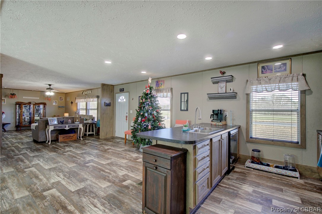 3029 Carsley Road Dendron, VA 23839 - Photo 17 of 26 Kitchen with a textured ceiling, stainless steel dishwasher, ceiling fan, sink, and light wood-type flooring