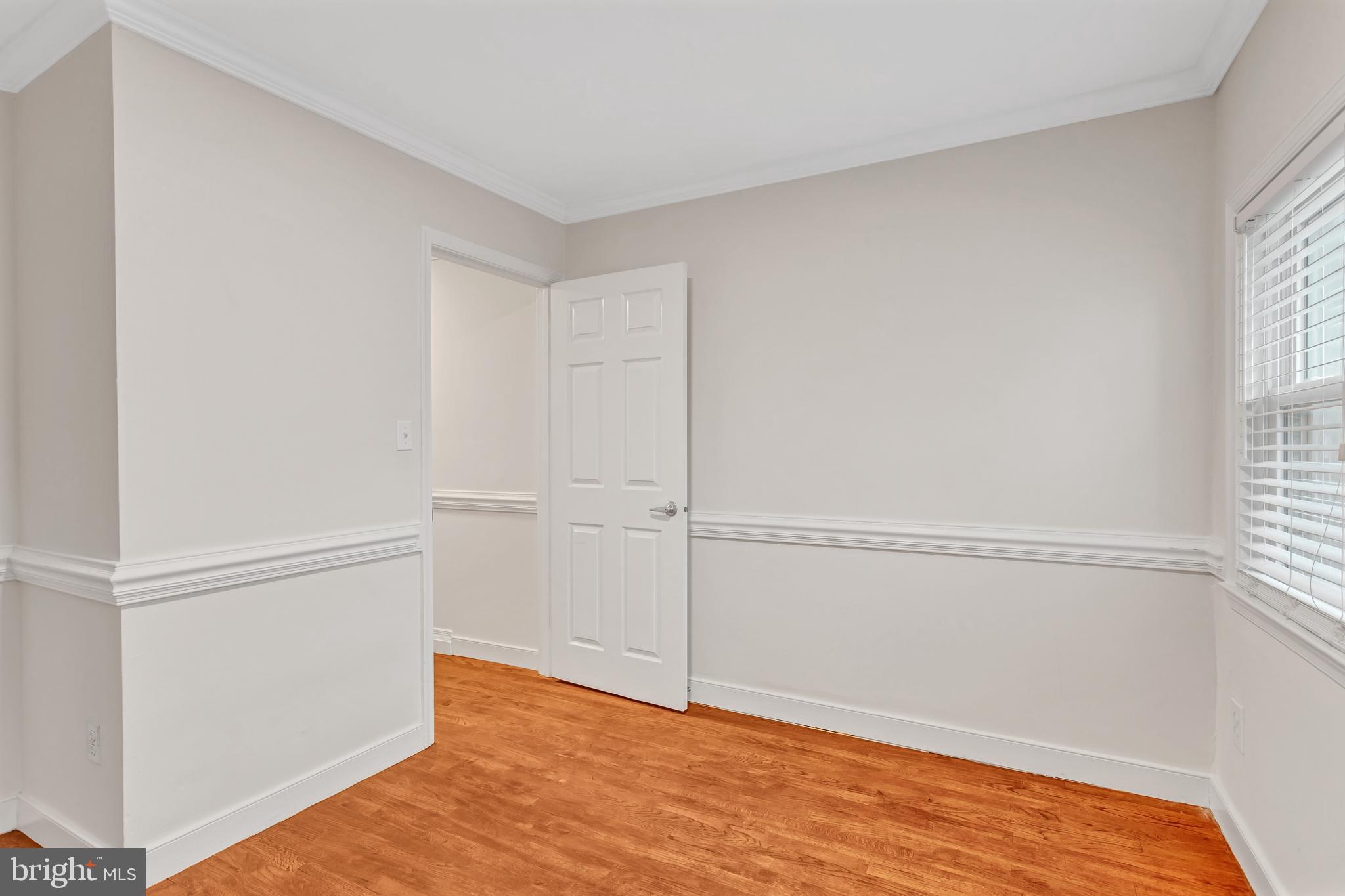 1437 Duke Street Alexandria, VA 22314 - Photo 25 of 45 a view of an empty room with wooden floor and a window