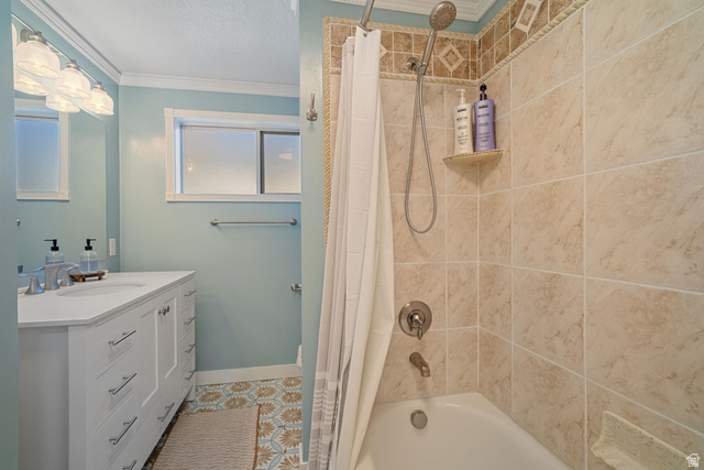 4426 South 3035 East Holladay, UT 84124 - Photo 16 of 49 Full bath with shower / bath combo, crown molding, vanity, light tile patterned floors, and a textured ceiling