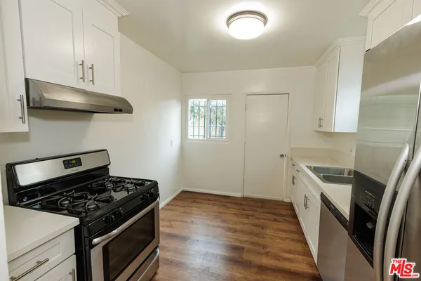 a kitchen with stainless steel appliances white cabinets and a refrigerator