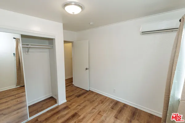 a view of a hallway with wooden floor and closet area