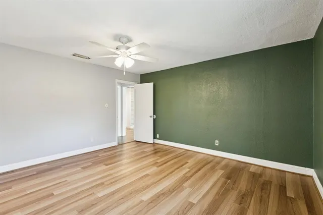 a view of an empty room with a ceiling fan and a window