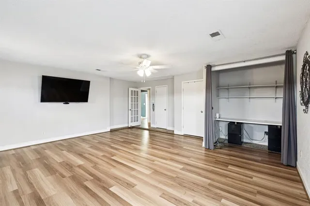 a view of empty room with wooden floor and fireplace