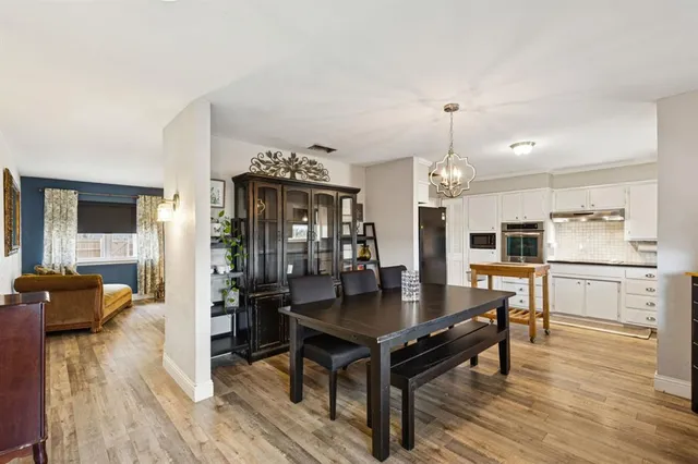 a kitchen with a dining table chairs and refrigerator