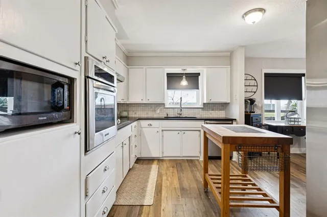 a kitchen with stainless steel appliances a stove a sink and a microwave