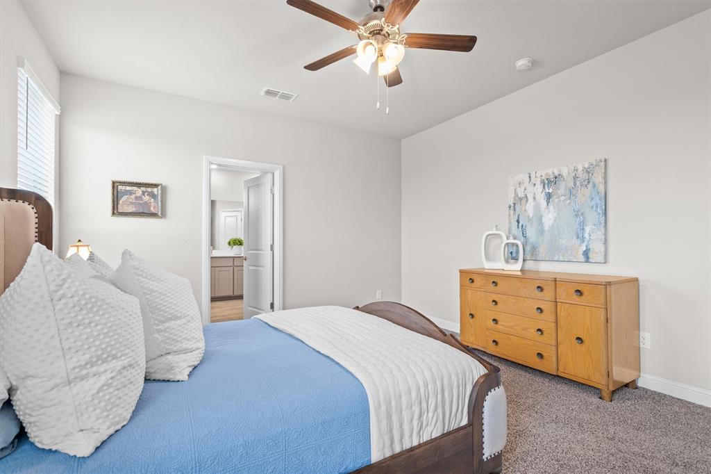 1864 Mensa Drive Haslet, TX 76052 - Photo 25 of 40 a bedroom with a bed and a chandelier
