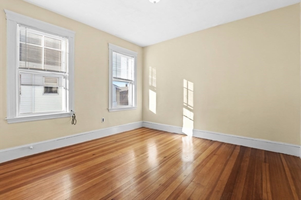 141 4th Street Medford, MA 02155 - Photo 14 of 26 a view of an empty room with wooden floor and a window