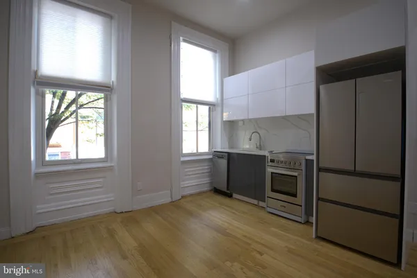 a kitchen with granite countertop a refrigerator and wooden cabinets