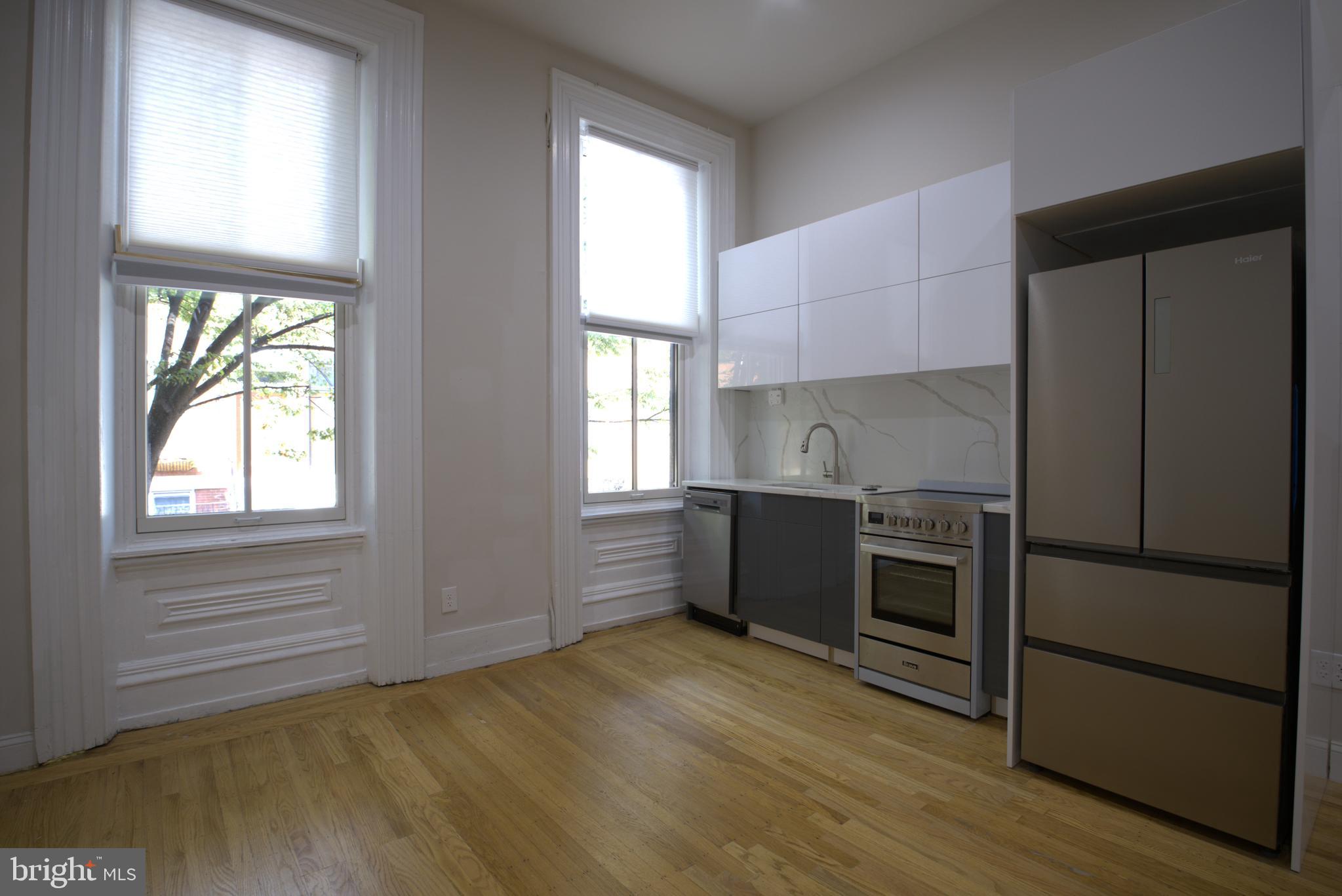 333 South 21st Street, Unit 1F Philadelphia, PA 19103 - Photo 1 of 15 a kitchen with granite countertop a refrigerator and wooden cabinets