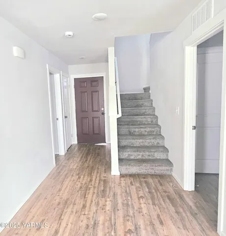 a view of a hallway with wooden floor and entryway