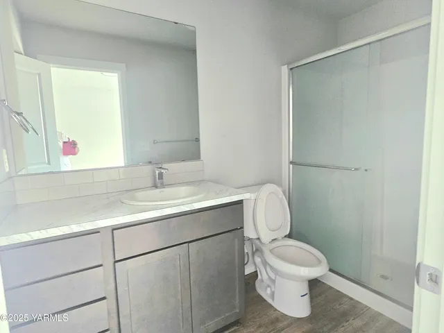 a bathroom with a toilet sink vanity and mirror