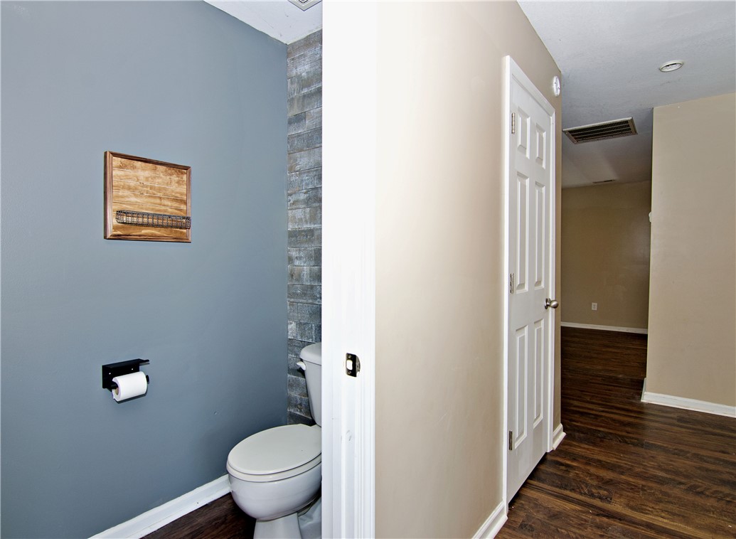 305 North Chestnut Street Seneca, SC 29678 - Photo 20 of 44 Functional half bath with stylish accent wall and robust wood-look flooring.
