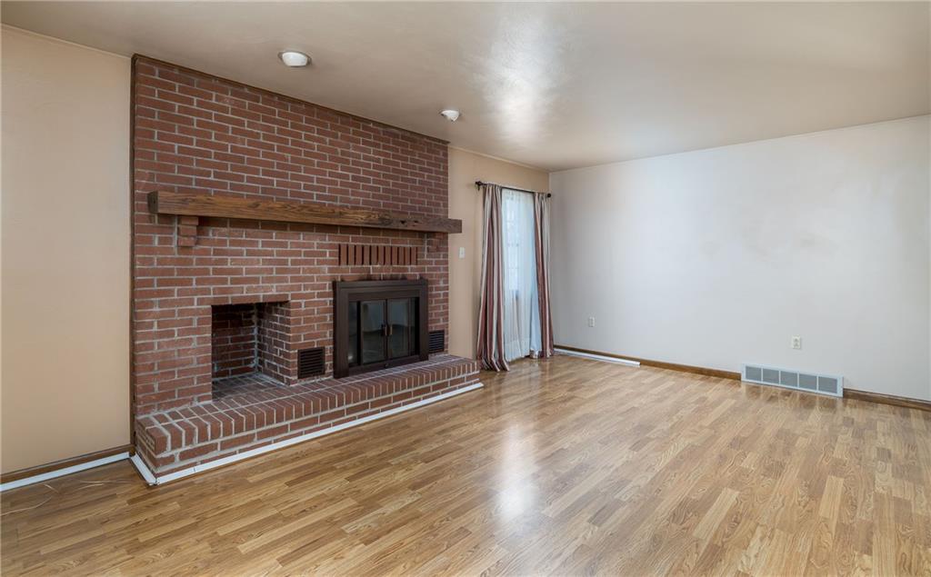 17 Cranberry Lane Cecil, PA 15321 - Photo 4 of 25 an empty room with wooden floor and fireplace