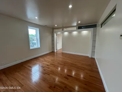 a living room with furniture wooden floor and a window