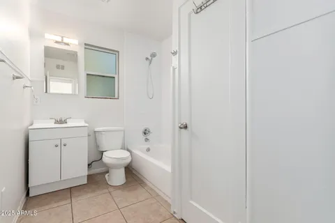 a bathroom with a toilet sink vanity and mirror