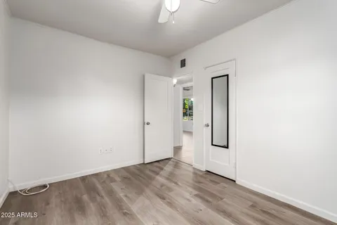 an empty room with wooden floor and mirror
