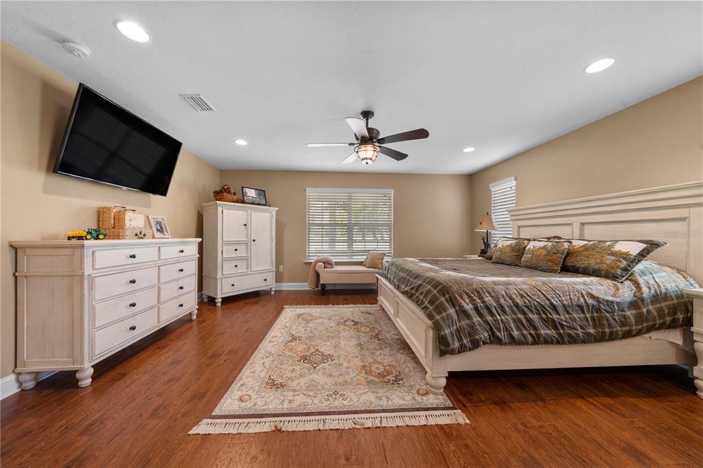 4639 Southwest Wilson Springs Road Fort White, FL 32038 - Photo 16 of 76 a spacious bedroom with a bed and a flat screen tv