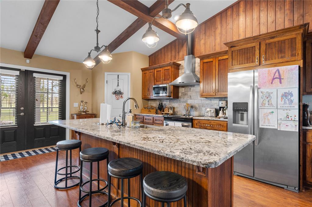4639 Southwest Wilson Springs Road Fort White, FL 32038 - Photo 2 of 76 a kitchen with stainless steel appliances granite countertop a kitchen island a table and chairs in it