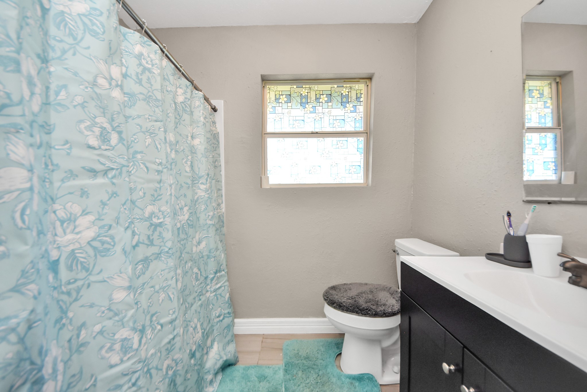 817 Church Street Crosby, TX 77532 - Photo 14 of 18 a bathroom with a granite countertop toilet a sink and a window