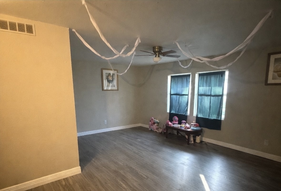 817 Church Street Crosby, TX 77532 - Photo 5 of 8 an empty room with wooden floor and windows